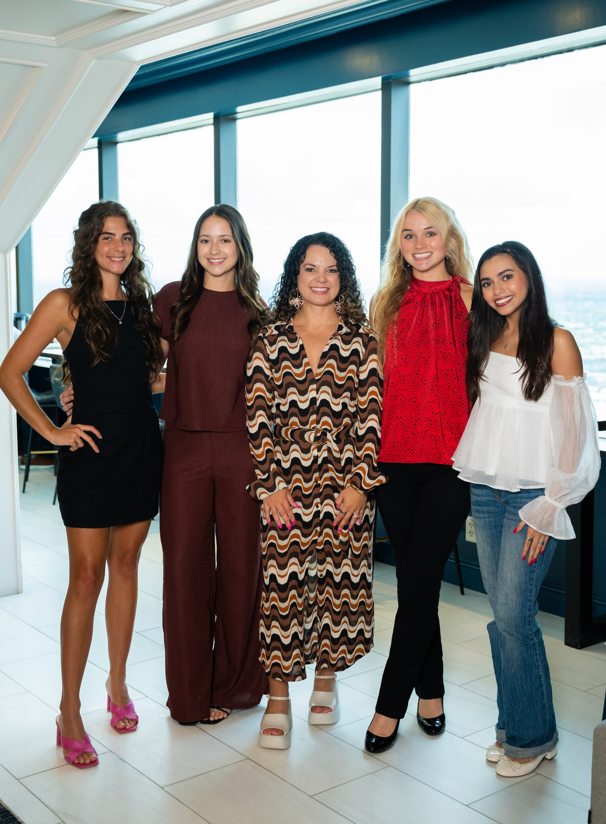 The Rosarium Collective team — five women at the Tampa Club overlooking the city skyline